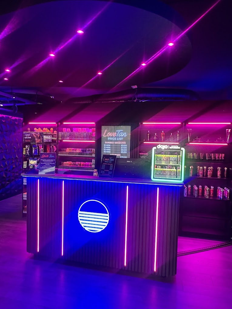 Love Tan's neon-lit reception with tanning products and price list